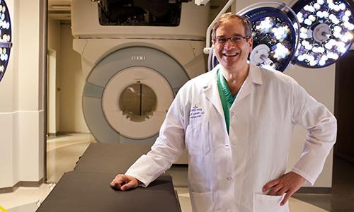 Dr. Henry Brem standing in front of an MRI machine.