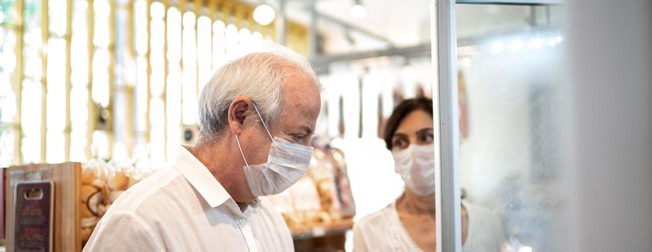 senior couple wears protective masks while shopping