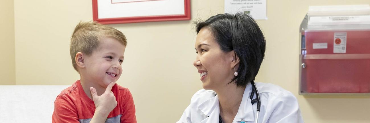 Female doctor laughing with little boy