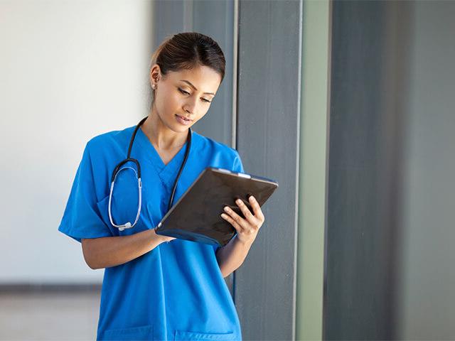 physician holding clipboard and wearing stethoscope 